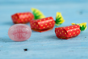 Wrapped candies on old wooden table