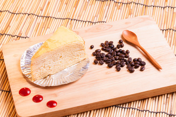 vanilla crape cake and cup of coffee on wood.