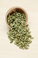 Cardamom pods in a wooden bowl