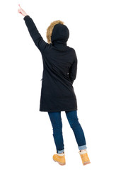 Back view of  pointing young women in parka.