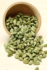 Cardamom pods in a wooden bowl