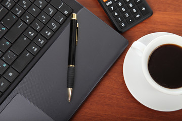 Calculator and cup of coffee on the financial documents