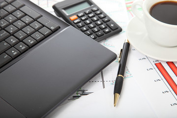 Calculator and cup of coffee on the financial documents