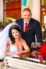 Bride and groom drinking coffee at an outdoor cafe