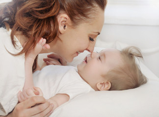 happy caring mother playing with her cute baby boy