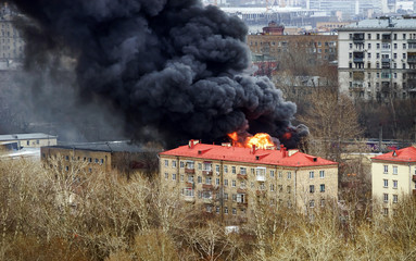 Column of black smoke rising above fireplace in the city