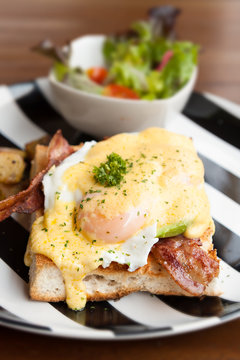 eggs benedict  breakfast bacon poached egg, potaots and salad