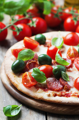 Italian hot pizza with salami, olive and tomato