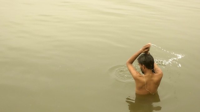 india, varanasi, man bathing in ganges river