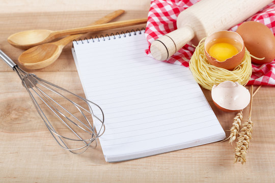 Baking ingredients for cooking and notebook for recipes.