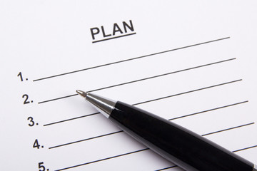 close up of sheet of paper with plan and pen