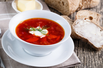 Tasty soup with bread on a wooden background.