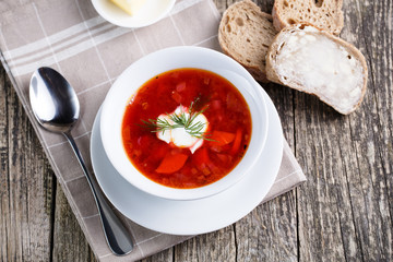 Tasty soup with bread on a wooden background.