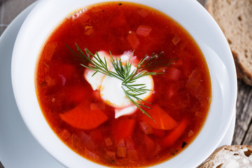Tasty soup with bread on a wooden background.