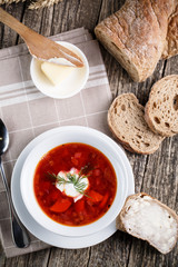 Tasty soup with bread on a wooden background.