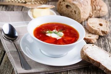 Tasty soup with bread on a wooden background.