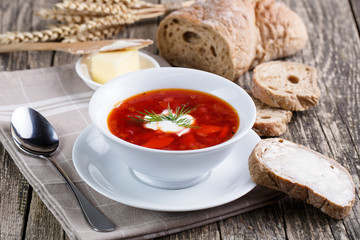 Tasty soup with bread on a wooden background.