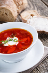 Tasty soup with bread on a wooden background.