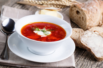 Tasty soup with bread on a wooden background.