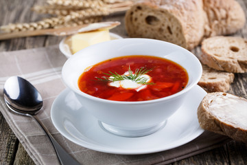 Tasty soup with bread on a wooden background.