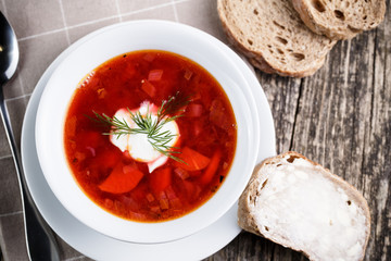 Tasty soup with bread on a wooden background.