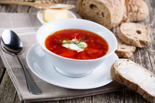 Tasty soup with bread on a wooden background.