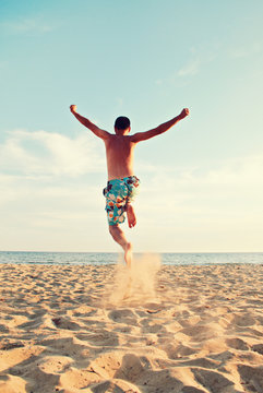 man jumping at beach - summer holidays