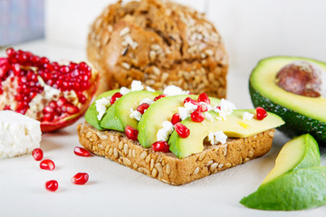 Avocado with Feta, pomegranate on sunflower seeds bread sandwich