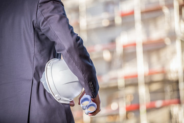 White helmet and blueprints on construction site