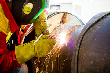 Close up shot welder until welding, sparks flying around.
