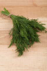 Bunch of fresh dill on a wooden board.