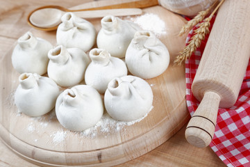 Baking ingredients for cooking manti dumplings on a wooden board