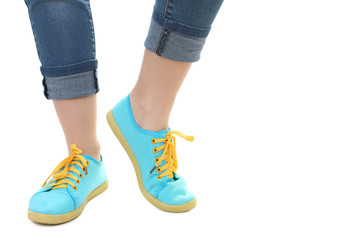Blue sneakers on girl, young woman legs, isolated
