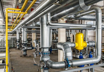 interior industrial gas boiler with a lot of piping, pumps and v