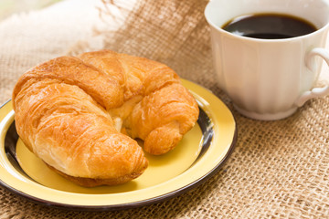 breakfast with croissants, cup of black coffee and newspaper