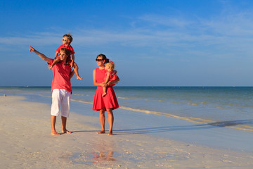 Young family with two kids walking at the beach