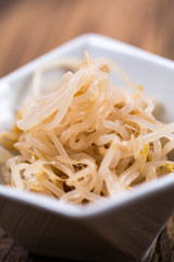 Fresh platter of bean sprouts with chopsticks on wooden table