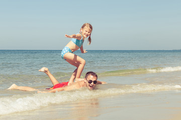Fototapeta premium Father and daughter playing on the beach at the day time.
