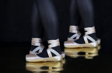 Ballerina -Tänzerin  - Beine mit Spitzenschuhe mit schwarzen Hintergrund