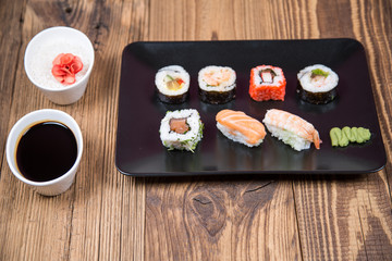 Sushi pieces collection with bamboo chopsticks, isolated on wooden table