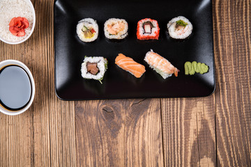 Sushi pieces collection with bamboo chopsticks, isolated on wooden table