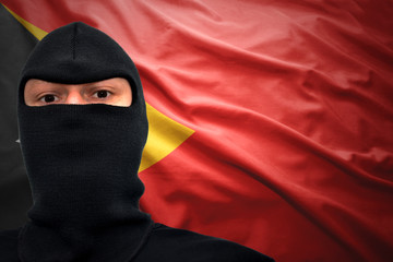 Portrait of man in mask against East Timor flag