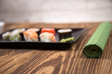 Sushi pieces collection with bamboo chopsticks, isolated on wooden table