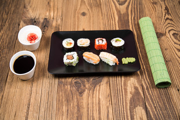 Sushi pieces collection with bamboo chopsticks, isolated on wooden table