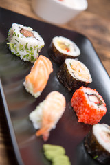 fresh Japanese tasty sushi roll set with chopsticks on wooden table