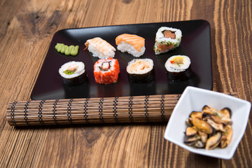 fresh Japanese tasty sushi roll set with chopsticks on wooden table