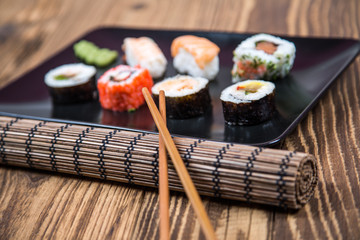 fresh Japanese tasty sushi roll set with chopsticks on wooden ta