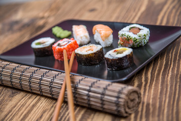fresh Japanese tasty sushi roll set with chopsticks on wooden ta
