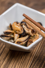 Fresh platter of mussel with chopsticks on wooden table