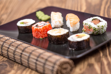 fresh Japanese tasty sushi roll set with chopsticks on wooden ta